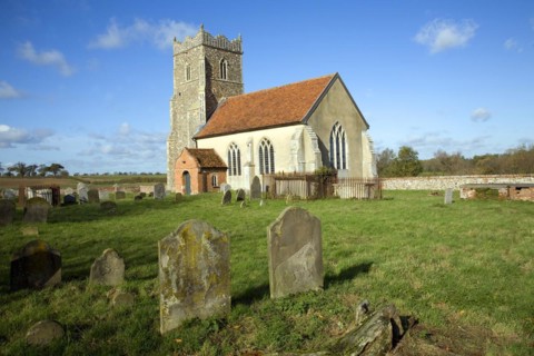 The Church of St Mary, Letheringham, Suffolk, England, now in the middle of far buildings is all