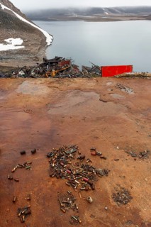 Rusted bullet casings, leaking rusty batteries and scrap metal, arctic settlement Ittoqqortoormiit,