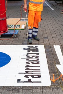 Application of road markings for a cycle lane, Rüttenscheider Straße in Essen, in the shopping and