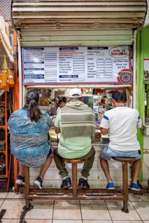 Visitors sitting at a food stall at the counter, Mercado Central de San José, San José, Costa Rica,