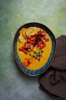 Pumpkin cream soup, curry, fried bacon, bruschetta chips, micro-greens, top view, no people