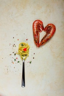 Spaghetti wrapped on a fork, langoustines heart shape, on the table, food concept, food background,