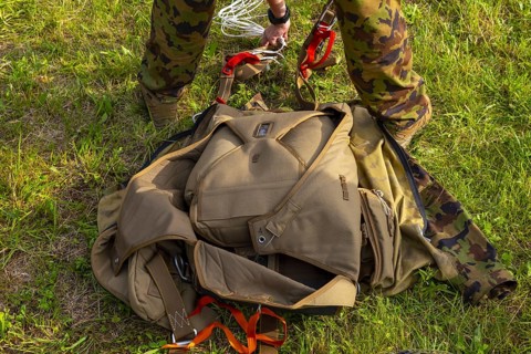 Military Parachuter Standing on the Grass with His Parachute in Switzerland