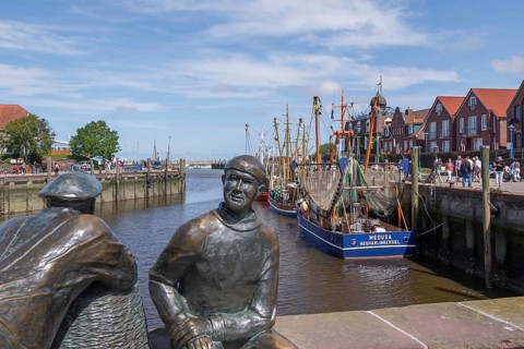 Sculpture of old and young fishermen at the cutter harbour Neuharlingersiel, East Frisia, Lower