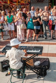 Young street musicians with happy crowd on the promenade in Swinoujscie, West Pomerania, Poland,