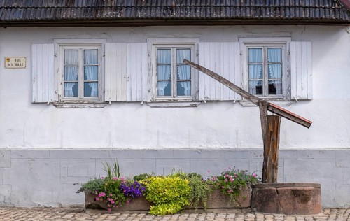 Old fountain in front of a house, Hunspach, Alsace, France, Europe