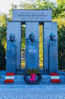 Monument to the Republic, decorated with a wreath of honour and red and white flowers, behind the