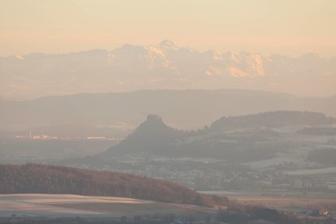 Hegaublick in winter and sunset. Hohenkrähen castle ruins with the Alps and the Säntis