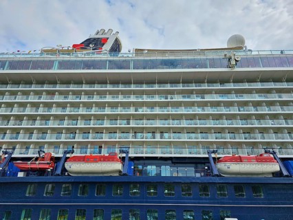Side view of a large cruise ship Mein Schiff 6, with several decks and attached lifeboats under a