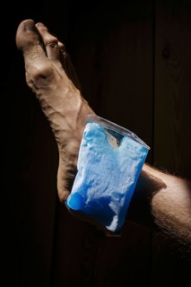 Symbolic photo on the subject of cooling for joint pain. A cooling pad is placed on an ankle and