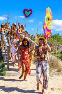 Colourfully dressed youths with musical instruments and banners form a love parade and promote the