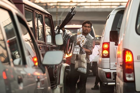 Street vendor standing between waiting cars, New Delhi or New Delhi, India, Asia