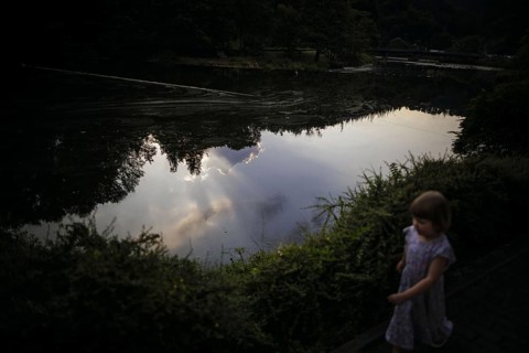 Symbolic photo on the subject of dangers on the water for small children. A little girl runs along