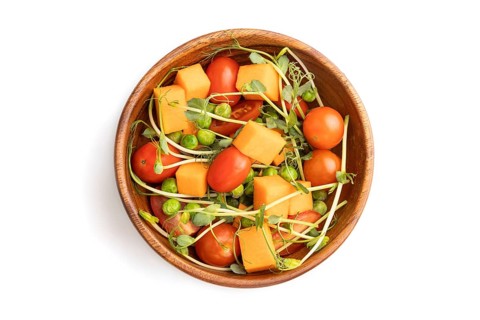 Vegetarian vegetable salad of tomatoes, pumpkin, microgreen pea sprouts isolated on white