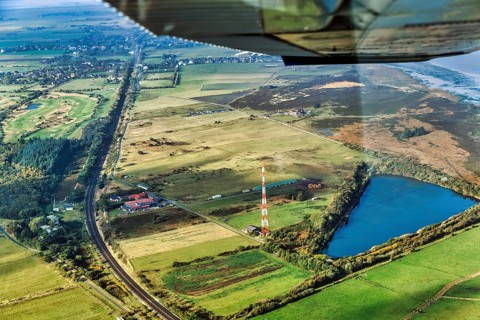 Railway tracks lead through meadows and fields, Morsum Teich Nösse Kuhle and transmission mast, NDR