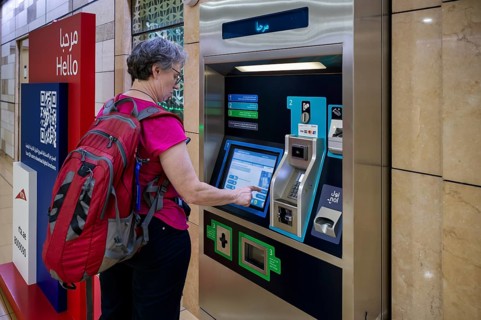 Interior shot, elderly woman, best ager at ticket machine, ticket terminal, Al Ras Station, train