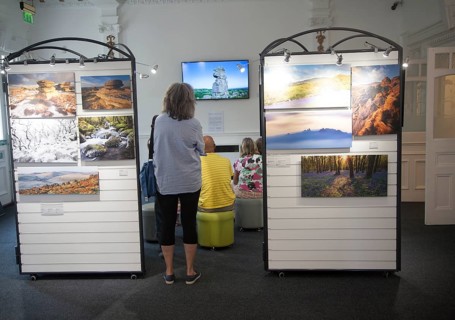 People watching a multimedia image display in the Dartmoor national park visitor centre,