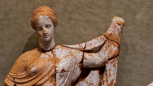 Ancient ceramic figurine of a woman with preserved paint remains, Archaeological Museum, Archea