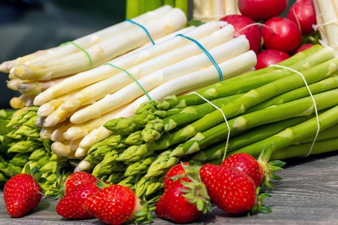 Green asparagus, white asparagus and fresh strawberries decorated on a rustic wooden table
