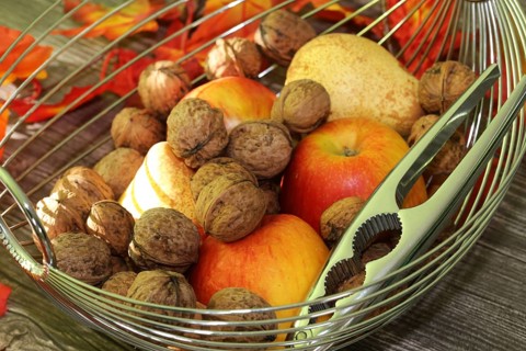 Apples, pears and walnuts on a rustic wooden table as an autumnal motif