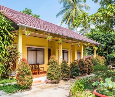 Small yellow hotel building in tropical resort