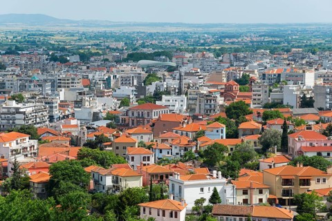 Panoramic view of a city with dense buildings and green areas under a cloudy sky, Xanthi, Eastern