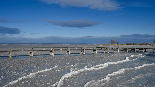 Frozen lake with ice and footbridge in winter, Lake Neusiedl, Podersdorf am See, Burgenland,