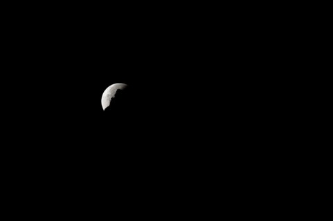 The moon disappears behind a mountain silhouette, taken in the Swiss mountains, Switzerland, Europe