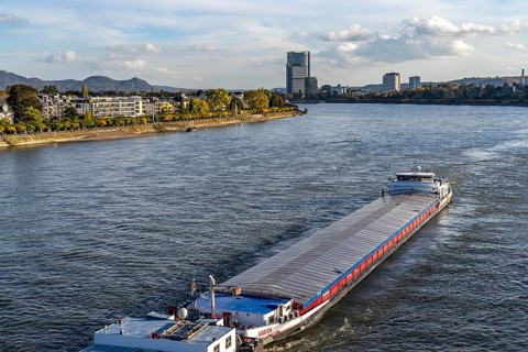 Cargo ship on the Rhine near Bonn, in the background the Post Tower, UN Campus, North