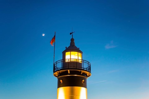 Upper segment of an illuminated lighthouse at night, black and white lighthouse, called 'Kleiner