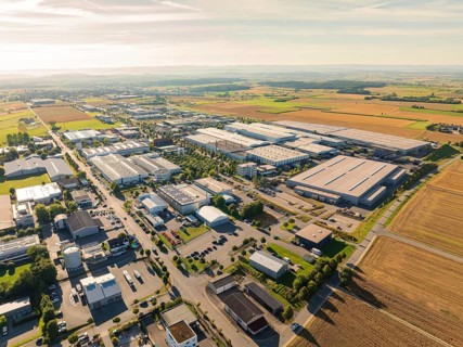 A large industrial area with factories, roads and surrounding fields in a rural area, taken from a