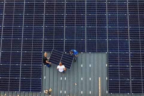 Installation of solar modules on the roof of a barn on a farm, over 210 photovoltaic modules are