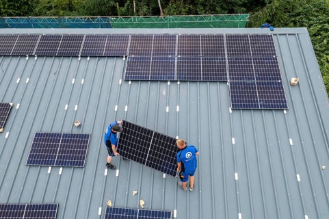 Installation of solar modules on the roof of a barn on a farm, over 240 photovoltaic modules are