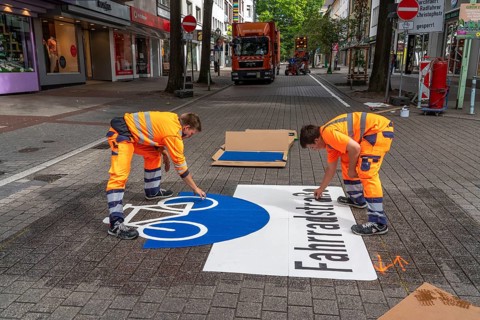 Application of road markings for a cycle lane, Rüttenscheider Straße in Essen, in the shopping and