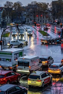 Rainy weather, road traffic, intersection, lights of vehicles on a wet road, traffic lights, tail