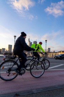 Skyline of the city centre of Frankfurt am Main, cyclist on the Ignatz-Bubis-Bridge, dusk, river