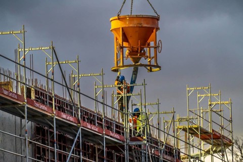 Concrete work, at dusk, on a large construction site building a residential and commercial complex,