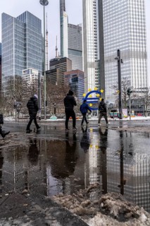 Winter in the city, Gallusanlage street, puddles, pools of water, melt water, pedestrians,
