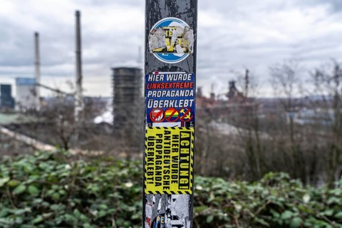Stickers of right-wing extremist groups pasted over stickers of apparently left-wing groups,