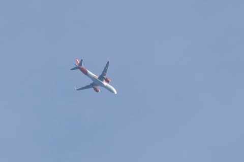Airbus A320 aircraft of Easyjet airlines in flight across a blue sky, England, United Kingdom,