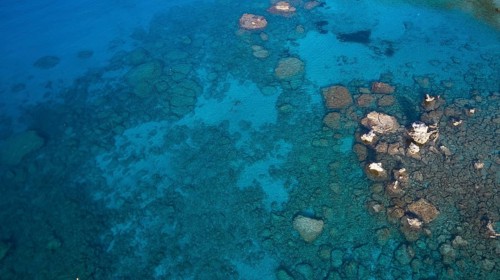 Drone shot, Clear view of the rocky seabed through azure waters revealing a tranquil underwater