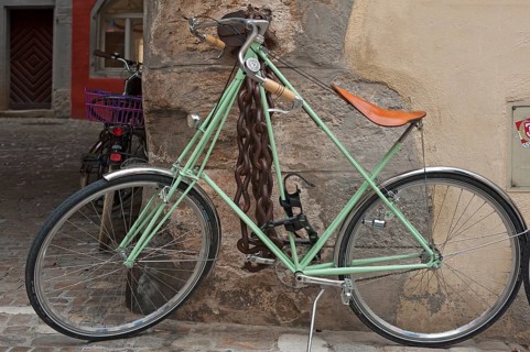 Modern bicycle chained to a house wall, heavy iron chain with lock on the wall behind, Regensburg,