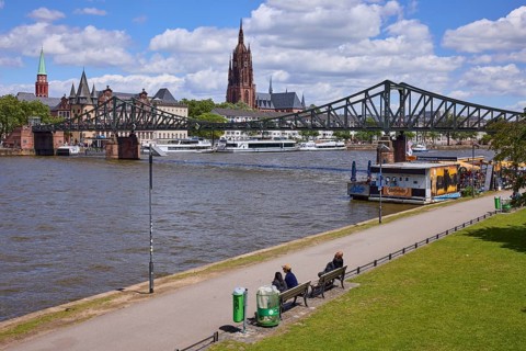 Iron footbridge with Main, riverside promenade and St Bartholomew's Cathedral in Frankfurt am Main,