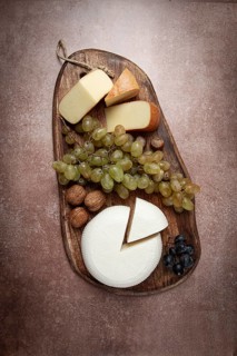 Georgian cheese, Imeretian and smoked suluguni, grapes, nuts, on a cutting board, Georgian cuisine,