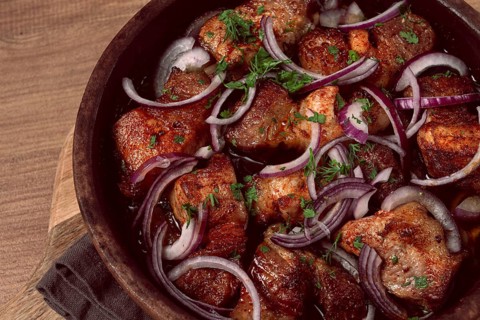 Fried meat, pork kebab, ketsi in a clay pan, with red onions and herbs, homemade, no people