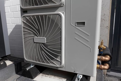 Outdoor units of a heat pump in front of a newly built two-family house, heating and air