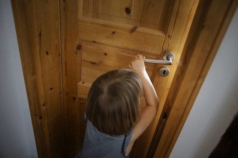 Symbolic photo: A small child opens a door in a flat. Berlin, 21.08.2024