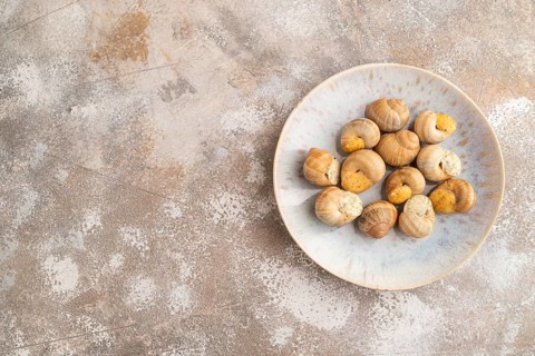 Grape (Burgundy) snails with butter and cheese on brown concrete background. Top view, flat lay,