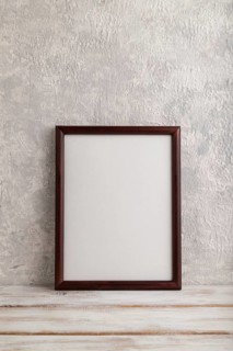 Brown wooden frame mockup on gray concrete background. Blank, vertical orientation, still life,