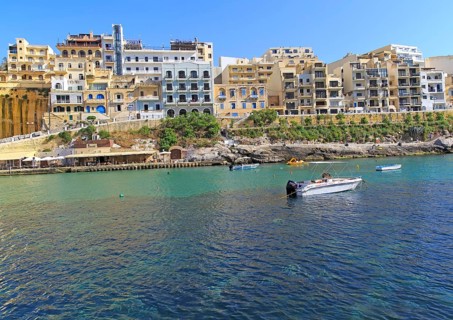 Waterfront hotel buildings beach and sea at Xlendi, island of Gozo, Malta, Europe